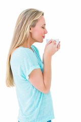 Pretty blonde standing and holding hot beverage