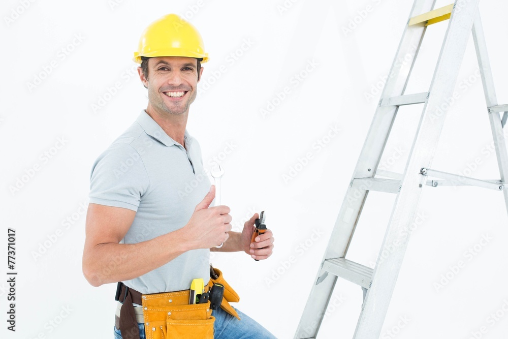 Poster technician with tools showing thumbs up by step ladder