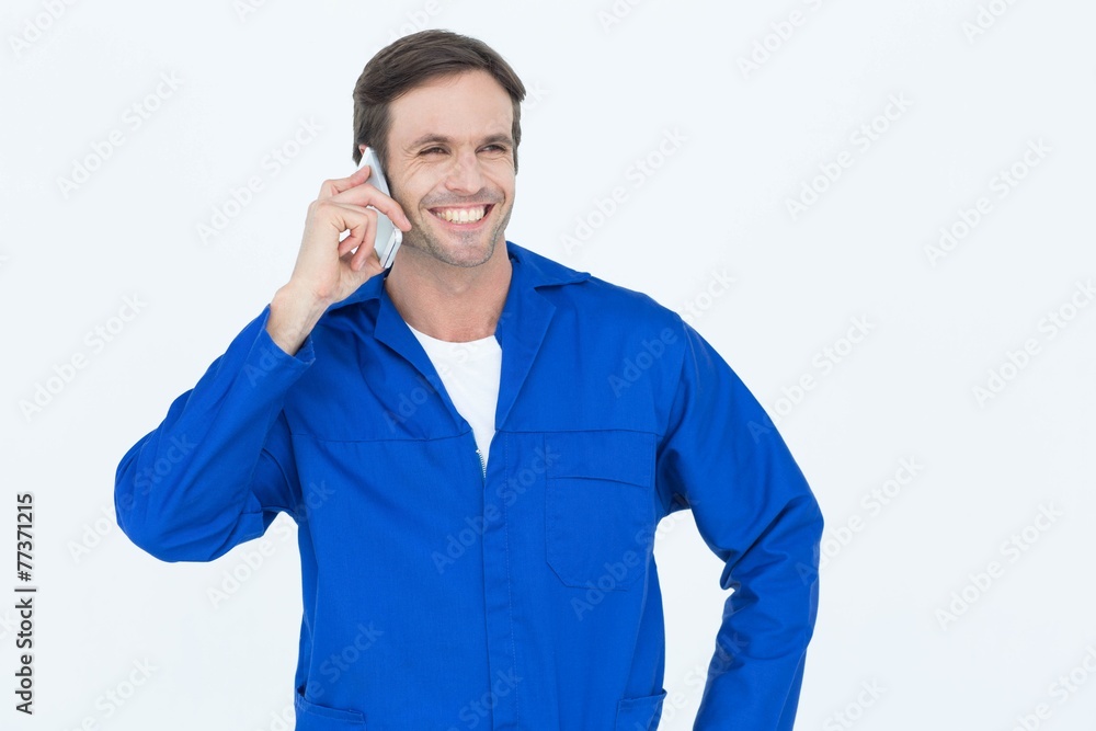 Poster Mechanic using mobile phone over white background