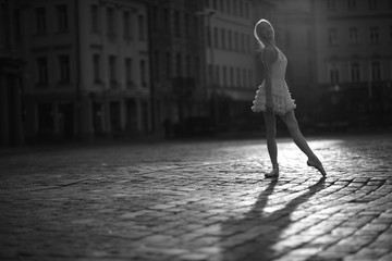 Fototapeta na wymiar Ballerina standing in the city square, monochrome