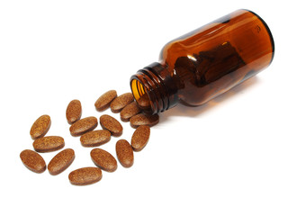 Pills spilling out of a pill bottle isolated on white background