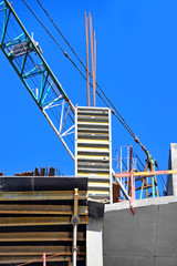Naklejka premium Crane and building construction site against blue sky