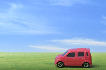 Obraz na płótnie Canvas 青空と草原と赤いワゴン車