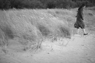 Tired woman walking alone outdoors, monochrome