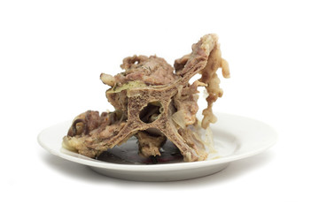 Bone with meat on a plate. Photo.