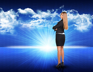 Fototapeta na wymiar Businesswoman standing against blue landscape with rising sun