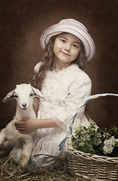 Portrait of a little girl with a baby goat