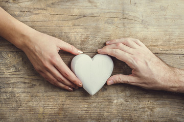 Hands of man and woman connected through a heart.