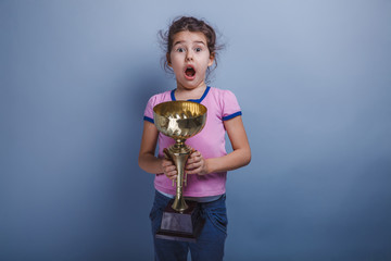 girl child 6 years of European appearance holds a cup in his han