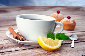 A cup of tea,muffin and lemon