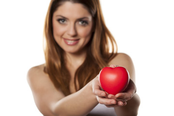 happy woman holds in her hand a heart shape object