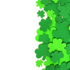St Patricks Day border of green shamrock confetti over white