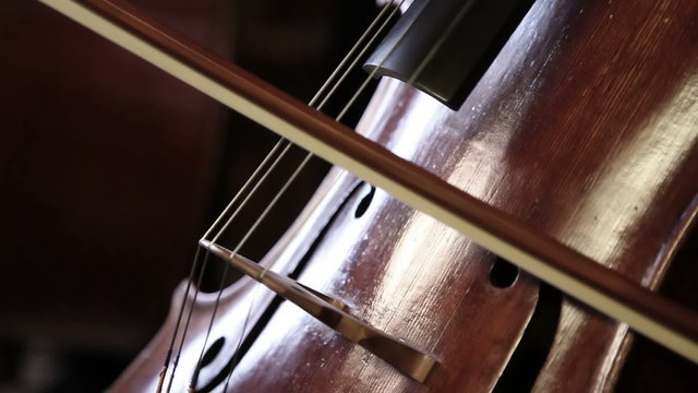Close up pan shot of a cello player