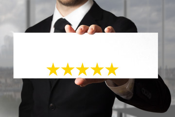 businessman holding sign five golden stars