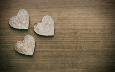 Obraz premium Three wooden hearts on a grungy wooden background