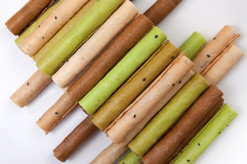 Heap of waffle rolls on white plate