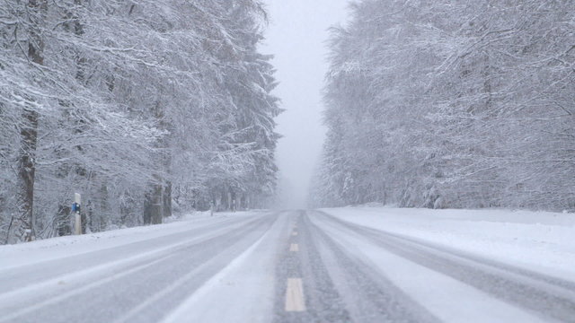 Snowfall on a Snowy Mountain Road at Dusk