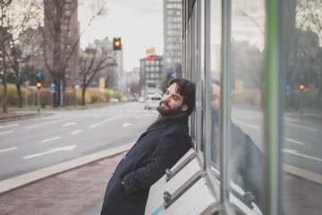 Young handsome bearded man posing in the city streets