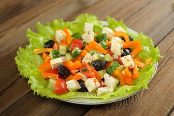 Greek salad with lettuce, olives, tomatoes, cucumbers and cheese