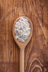 wooden spoon with flour on old board