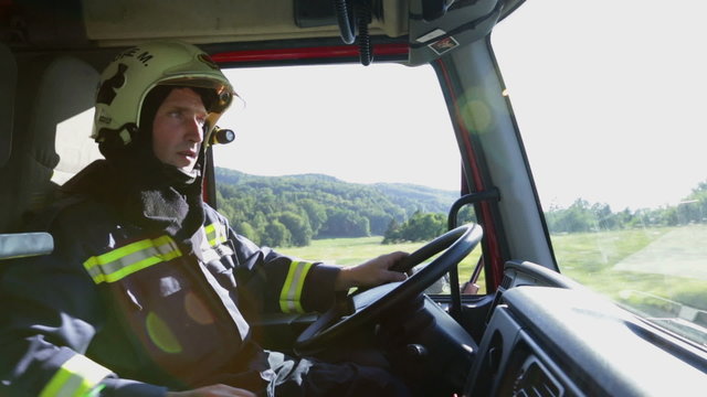 Firetrucks cockpit with a fireman at the wheel