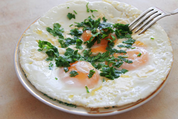 Fried eggs on the plate with a fork