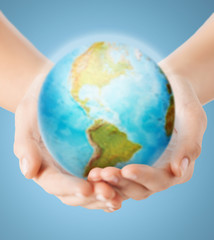close up of human hands with earth globe
