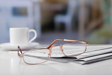 Glasses and newspapers, close-up
