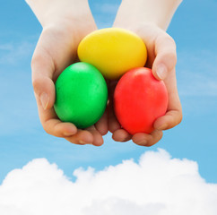 close up of kid hands holding colored eggs