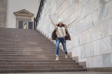 Beautiful young woman jumping down stairs