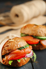 Sandwiches with salmon and vegetables on wooden background