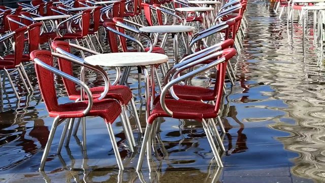 chairs and tables in a restaurant in venice during high tide