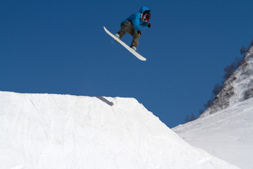 Naklejka na ściany i meble Snowboarder jumps in Snow Park, ski resort