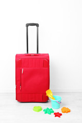 Red suitcase with child toys  isolated on white