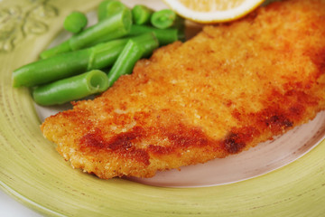 Breaded fried fish fillet and potatoes with asparagus and