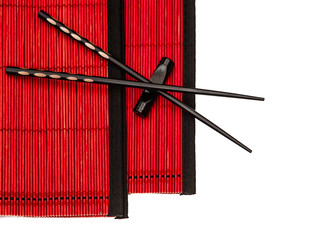 black chinese chopsticks on red bamboo mat. asian style