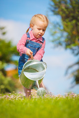 Beautiful smiling little girl helping in the spring work, garden