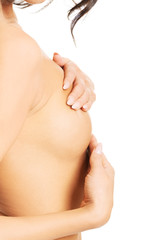 Fototapeta na wymiar Beautiful topless woman examining her breast