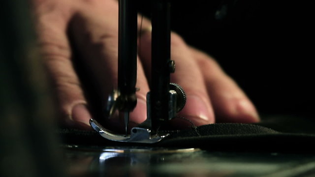Close up shot of a tailor behind a sewing machine