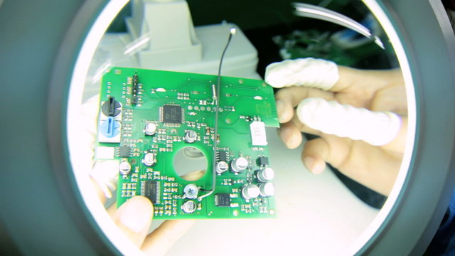Precision quality control checks Chinese worker PCBs, China