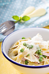 Bow ties pasta with ham and green peas