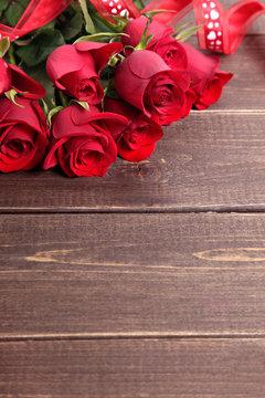 Valentine background of  red roses and ribbon on wood. Space for