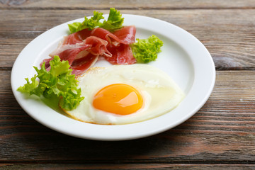 Bacon and eggs on rustic wooden planks background