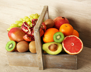 Assortment of exotic fruits in box on wooden background