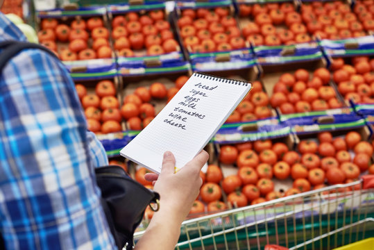 Shopping list in hands of woman in supermarket