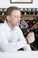 man smelling a red wineglass.