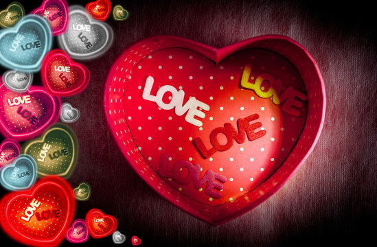 Heart-shaped gift box and text "LOVE" in box on dark background