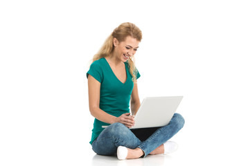 young colledge girl sitting on floor with laptop.
