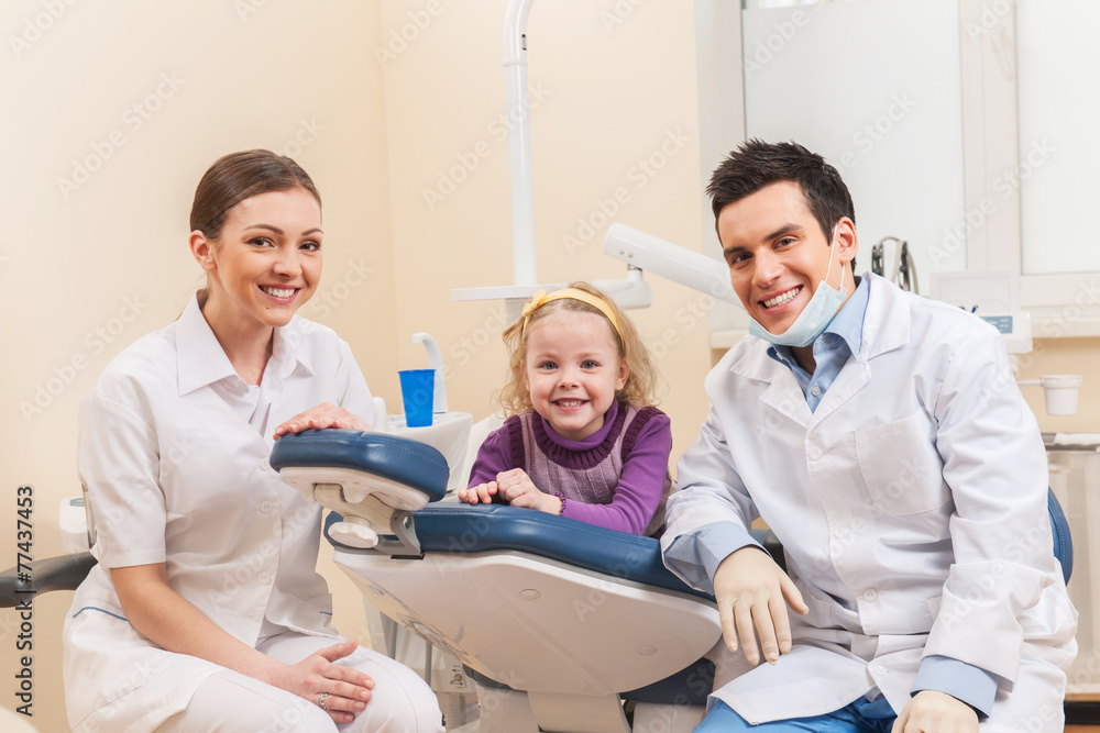 Wall mural little girl at dentist looking up and smiling.