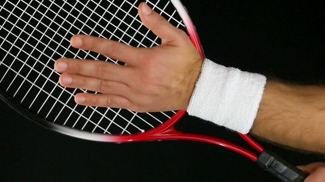 tennis player's hand hitting the net of his tennis racket